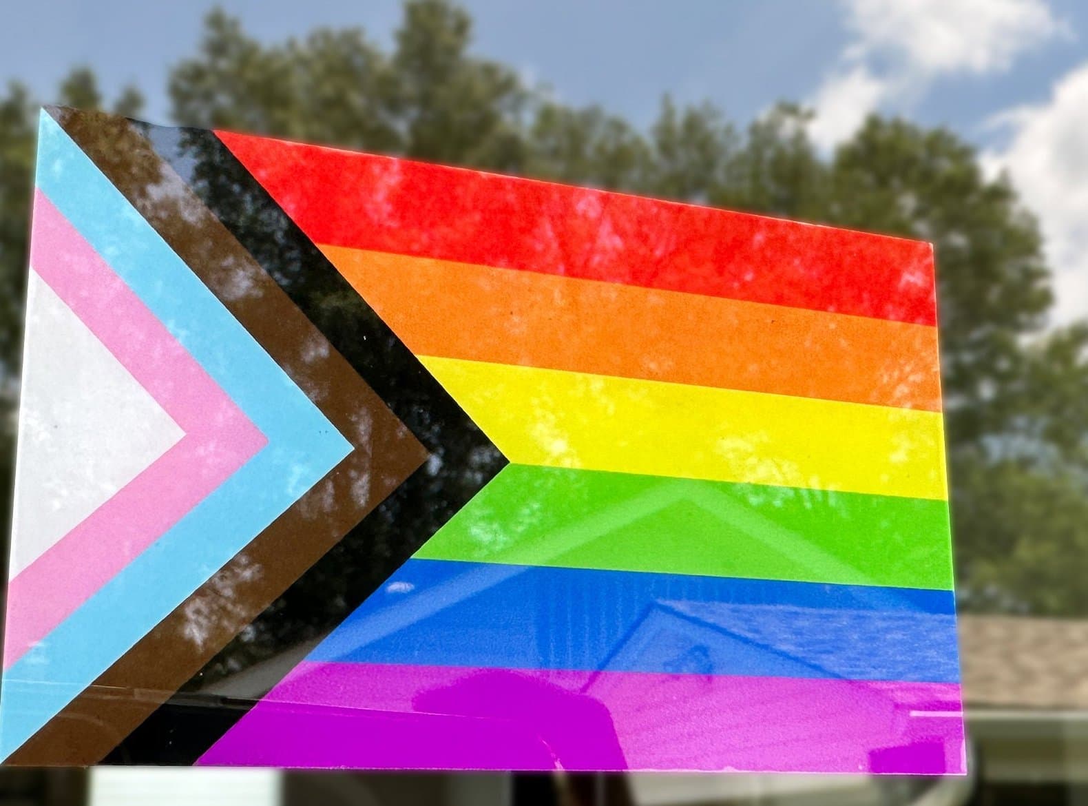 Progress Pride flag static window cling applied to a glass window