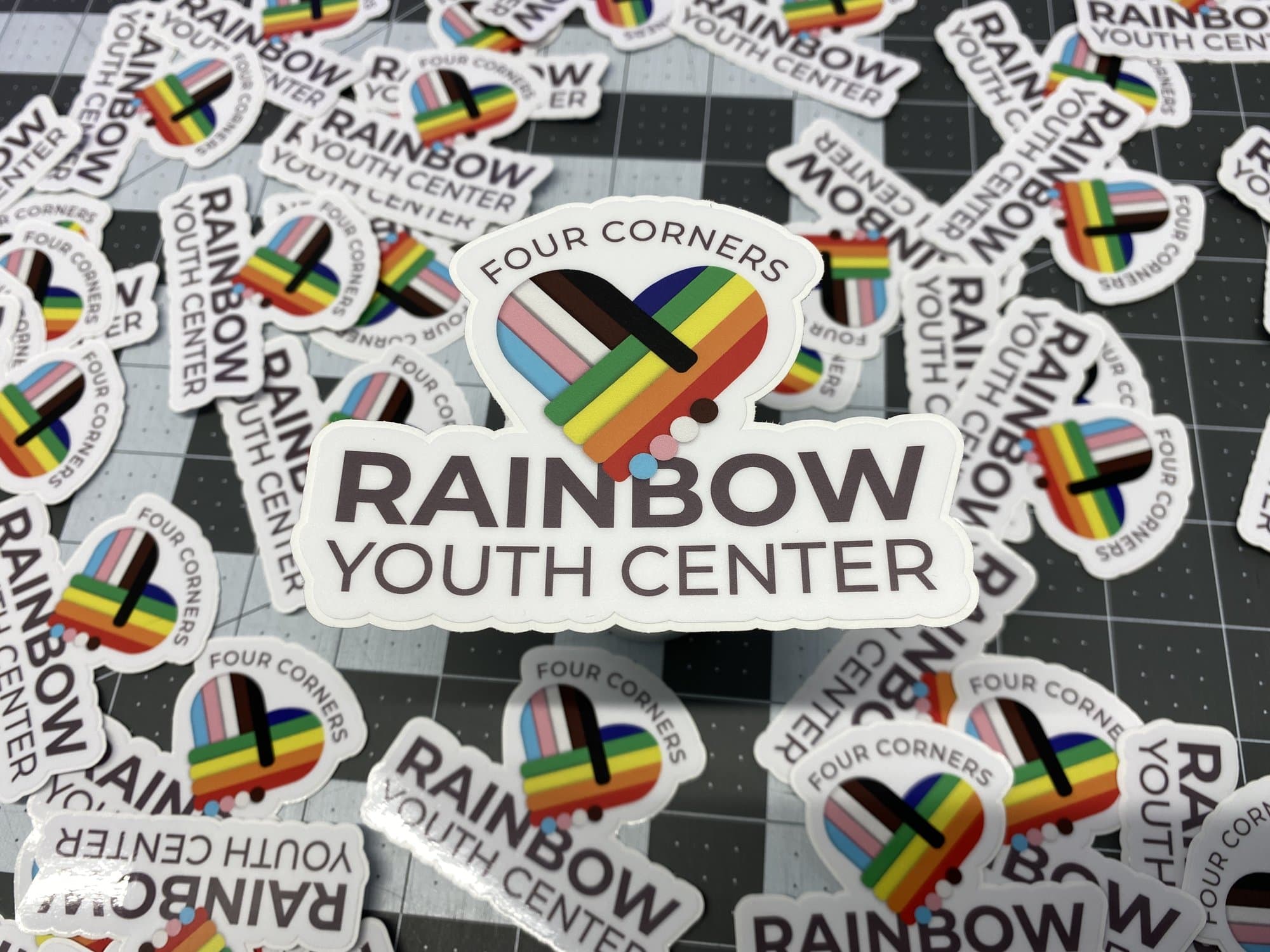 A pile of Four Corners Rainbow Youth Center die cut stickers