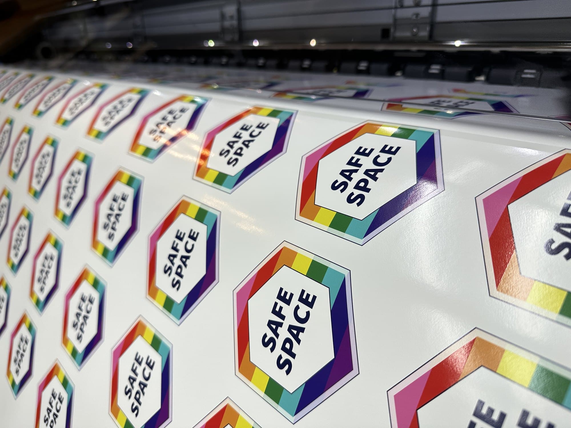 Rainbow Safe Space hexagon stickers coming off the printer